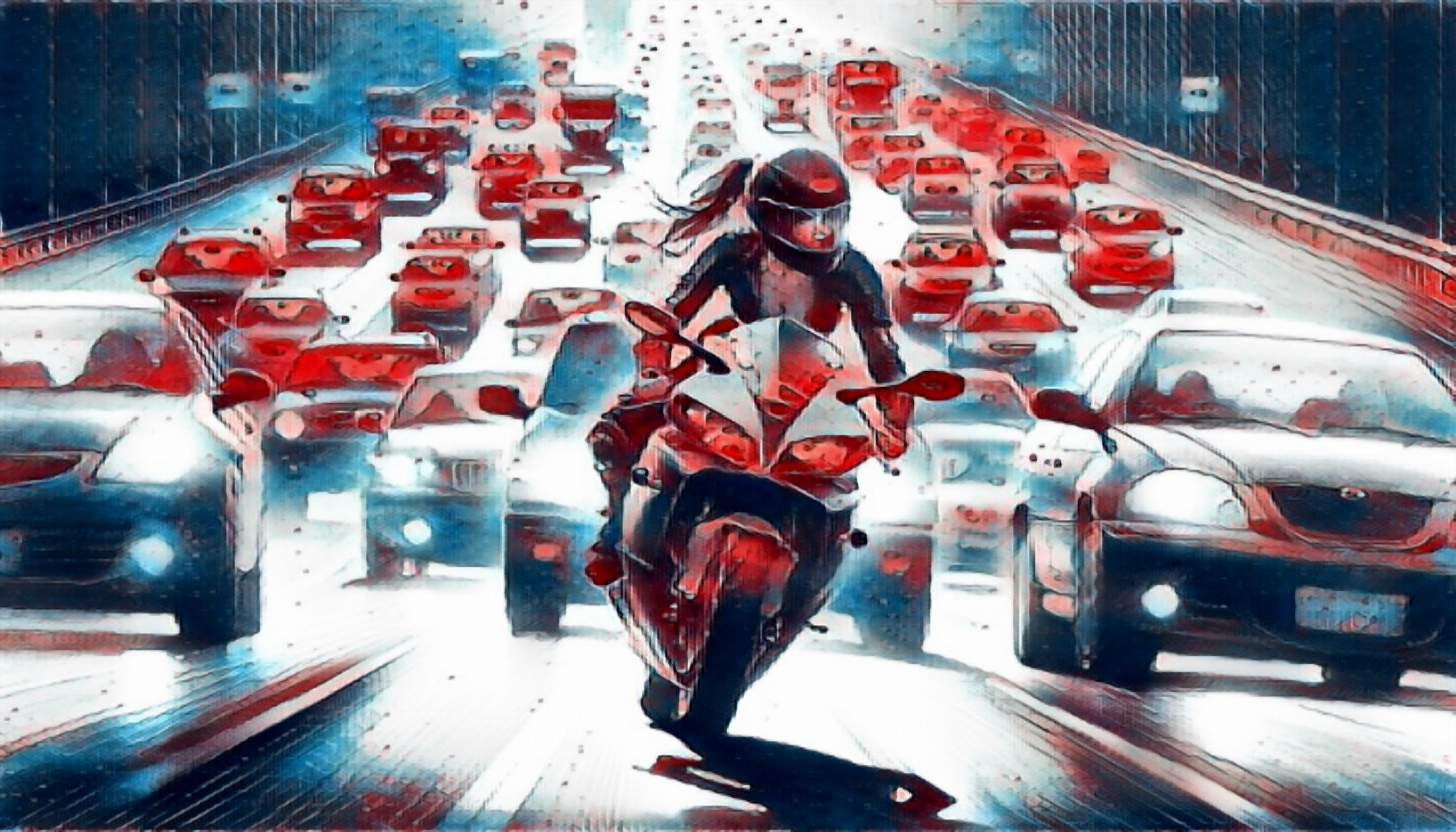 A motorcycle driving on a California highway congested with car traffic